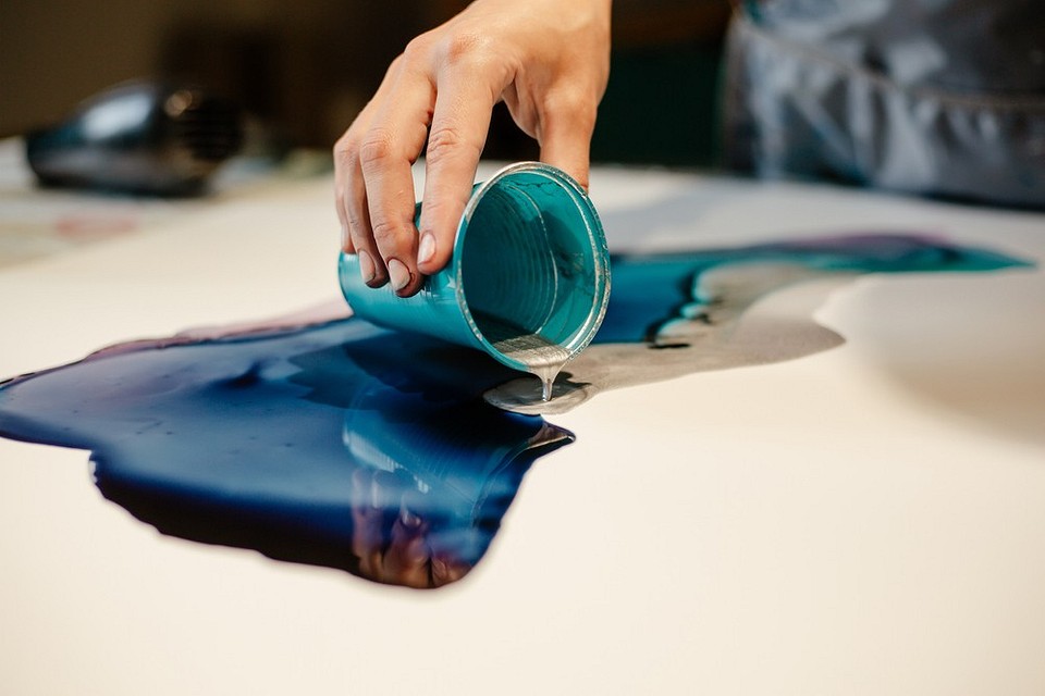 Proces tworzenia stołu z żywicy: zalewanie formy żywicą epoksydową.