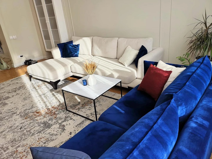 Narożnik velvet w loft Aranżacja salonu z niebieskim narożnikiem w stylu loft, wykonany z materiału velvet.