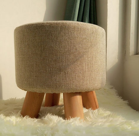 Kącik czytelniczy z pufem Miękki puf i wygodny fotel w rogu pokoju, idealne miejsce do czytania.