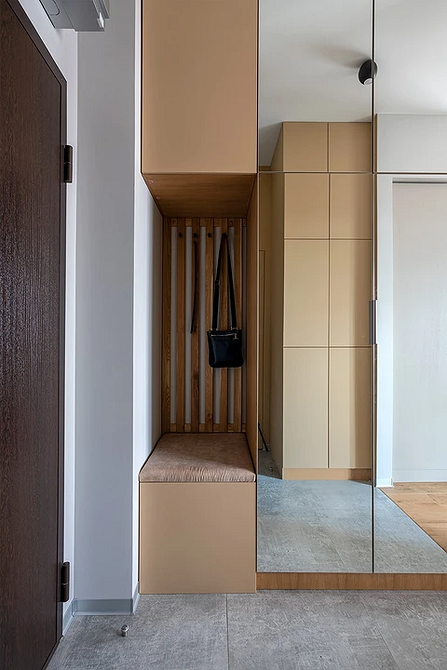 Nowoczesna szafa lustrzana w przedpokoju, optycznie powiększająca przestrzeń i służąca do przechowywania.