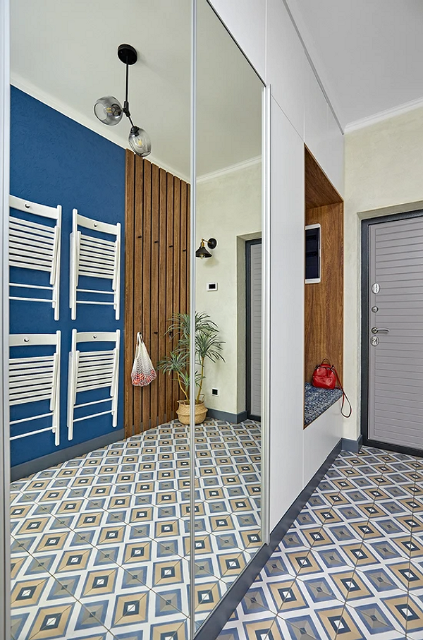 Duża szafa lustrzana w minimalistycznym salonie, akcent na funkcjonalność i powiększenie przestrzeni.