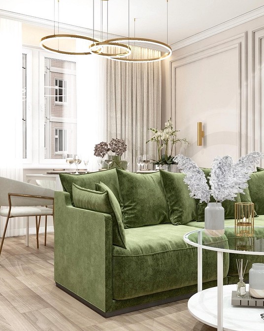 Skandynawska zielona sofa Zielona sofa w stylu skandynawskim z pledem i drewnianą podłogą.