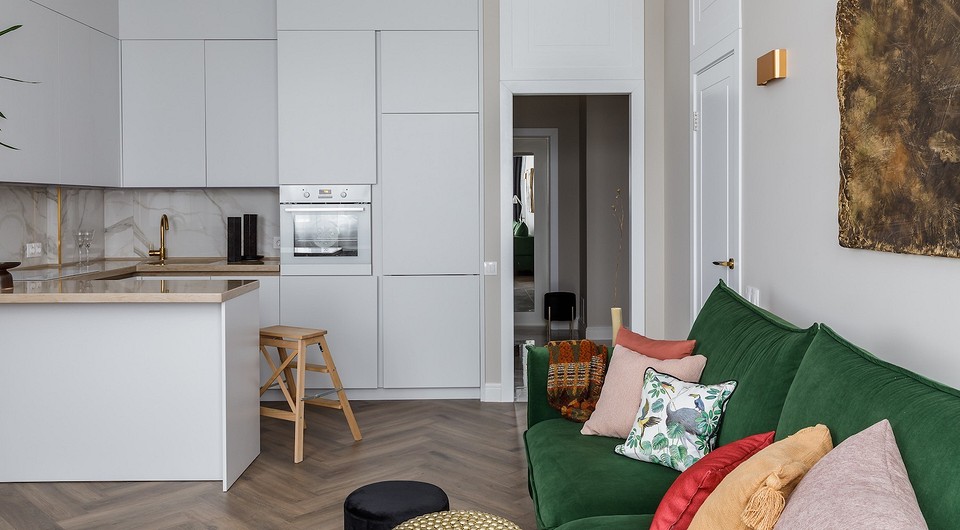 Zielona sofa w salonie Zielona sofa w salonie z poduszkami w różnych odcieniach zieleni, dodająca przytulności wnętrzu.