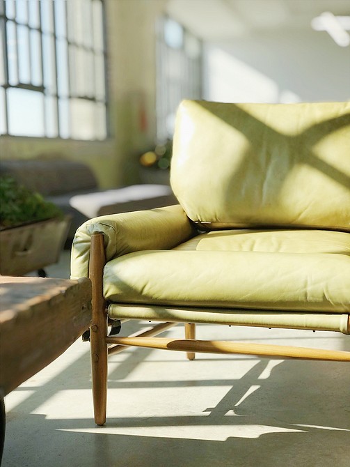 Zielona sofa z poduszkami Wygodna zielona sofa z poduszkami w różnych odcieniach zieleni w salonie.