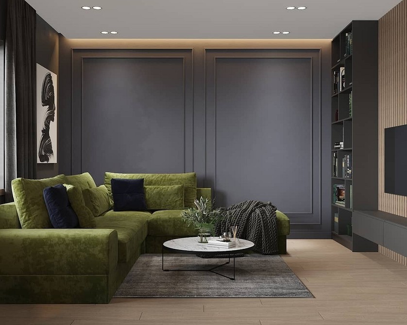 Salon z dwoma zielonymi sofami i dywanem z geometrycznym wzorem.