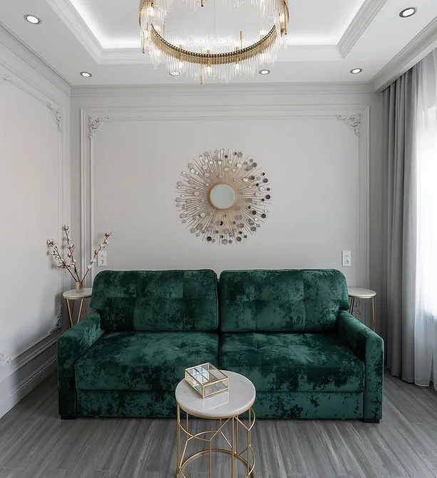 Narożna zielona sofa Narożna zielona sofa w salonie z dużymi oknami i roślinami, wprowadzająca świeżość do przestrzeni.