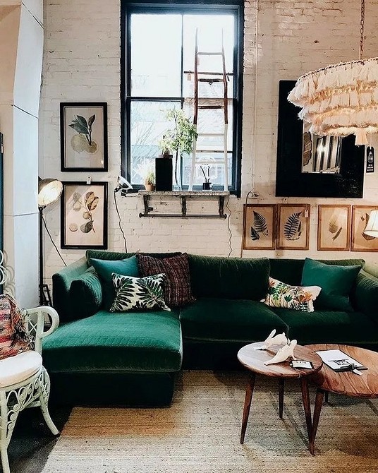 Zielona welurowa sofa Zielona welurowa sofa w salonie z dywanem w tym samym kolorze i złotymi detalami, dodająca blasku.