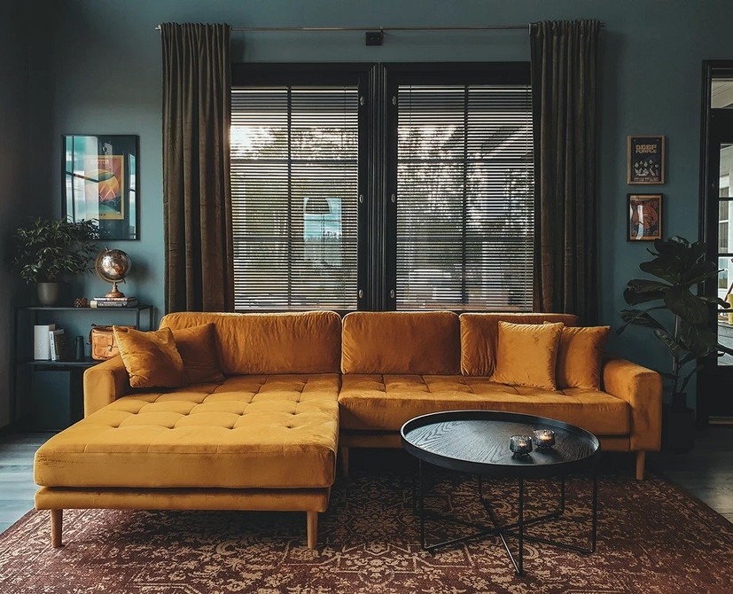 Mała żółta sofa w małym salonie z kolorowymi akcentami - oszczędność miejsca