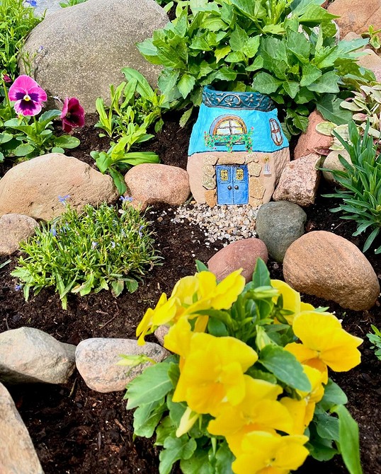 Alpinarium w Miniaturze Alpinarium w małym ogrodzie z kamieniami i niskimi roślinami górskimi.