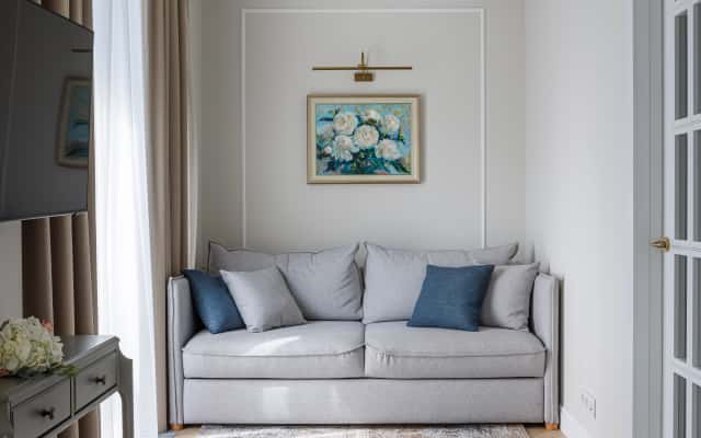 Salon w stylu neoklasycznym: sofa, dekoracje i aranżacja małego mieszkania.