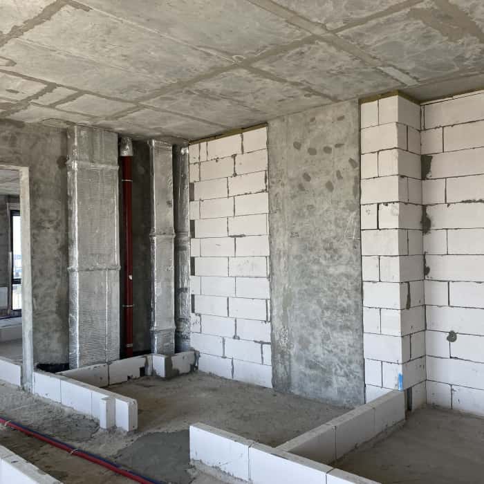 Wnętrze mieszkania bez wykończenia - surowe ściany czekają na remont i aranżację.