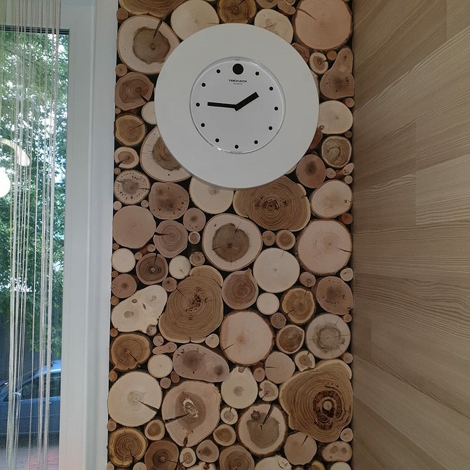 Nowoczesny salon z drewnem Nowoczesny salon z akcentem drewnianej ściany, szarą sofą i złotymi dodatkami