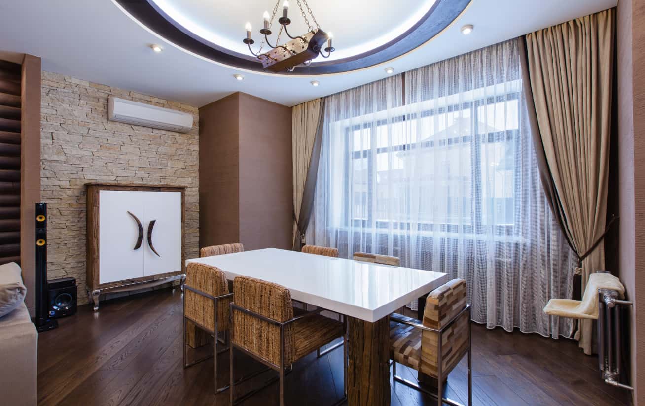 Luksusowe wnętrze w ciemnych barwach z wykorzystaniem ciemnego drewna i kominkiem.