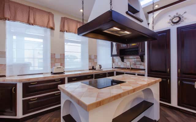 Stylowa jadalnia w ciemnych tonach z dużym drewnianym stołem i motywami azjatyckimi.