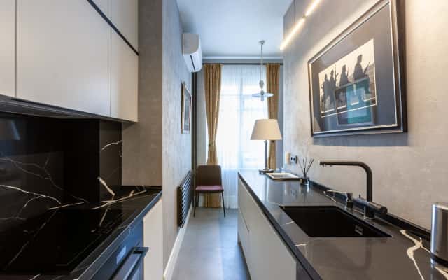 Męskie wnętrze 2026: salon z sofą w ciemnym odcieniu i elementami drewna.