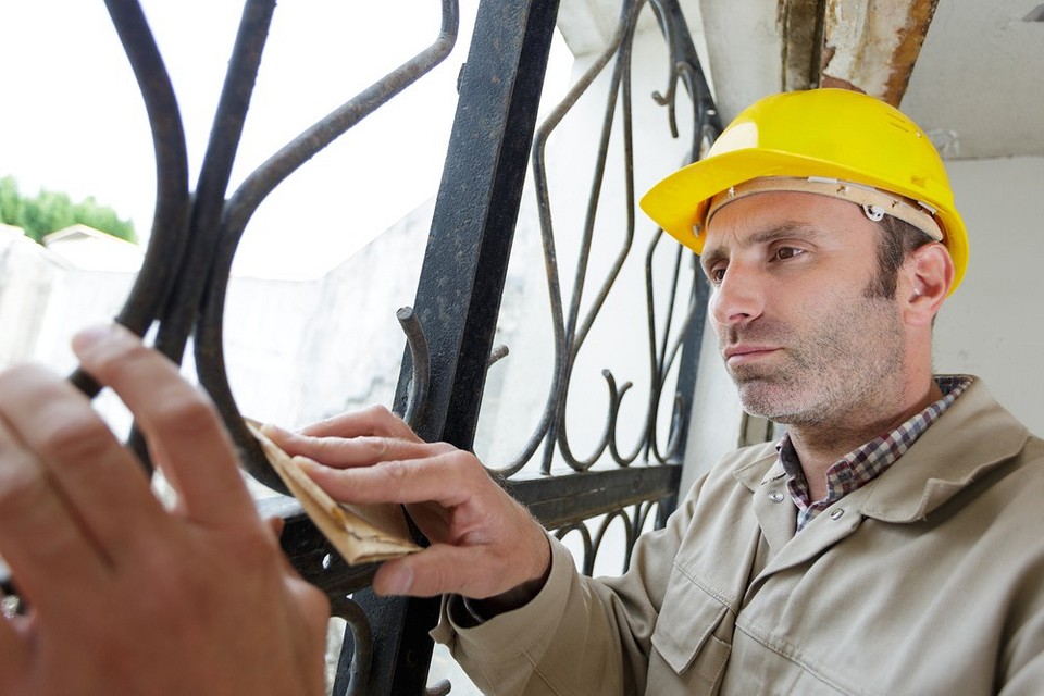 Szlifierka do metalu w akcji Mechaniczne usuwanie starej farby z metalowej powierzchni za pomocą szlifierki.