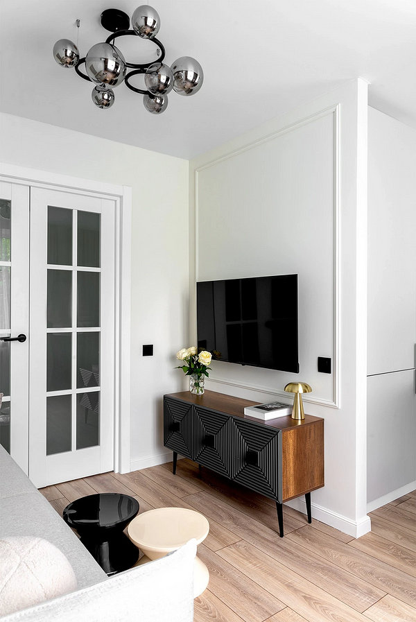 Nowoczesny design: białe listwy przypodłogowe kontrastują z ciemną podłogą i ścianami.