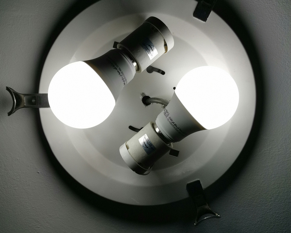 Grafika ilustruje prawidłowy sposób wyjmowania żarówki z lampy punktowej.