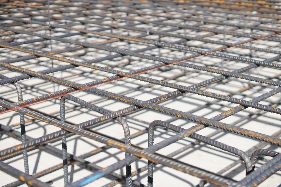 Wylewanie betonu DIY Ilustracja pokazuje proces wylewania betonu na przygotowane podłoże w garażu, rozprowadzanie betonu.