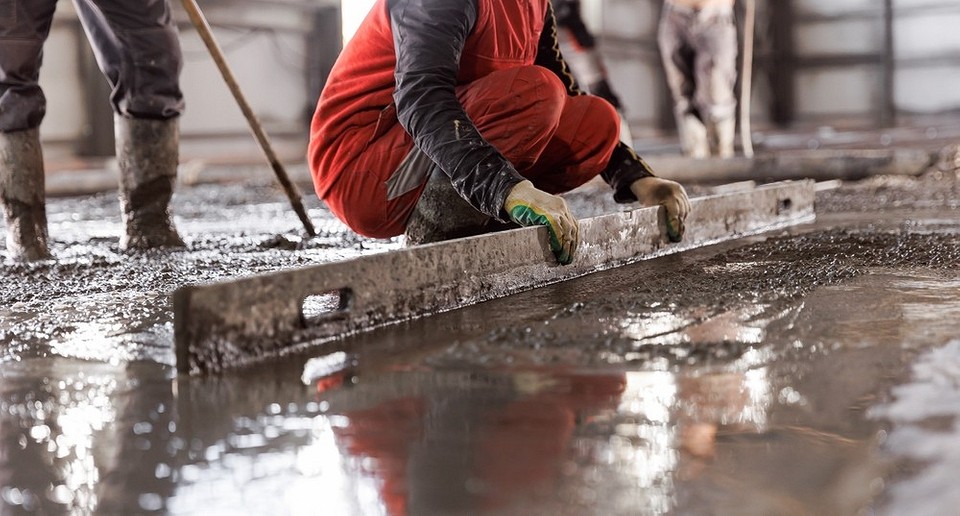 Poziomowanie wylewki Obraz pokazuje poziomowanie wylewki betonowej w garażu, użycie łaty i poziomicy.
