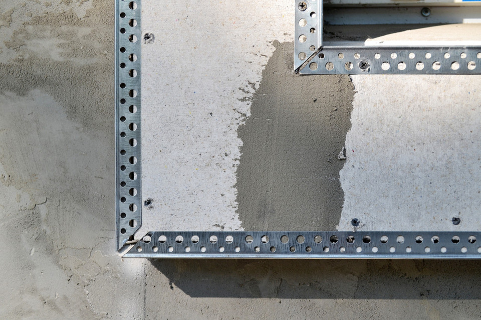 Pierwsza warstwa tynku Instrukcja nakładania pierwszej warstwy tynku na ościeże okienne dla izolacji domu.