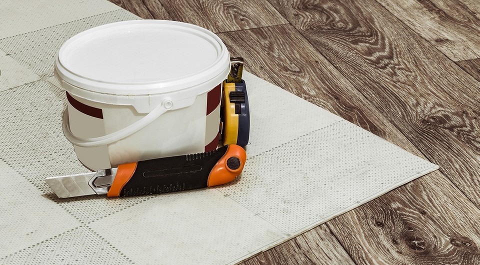 Zdjęcie przedstawia łączenie linoleum; widoczne narzędzia i klej do linoleum.