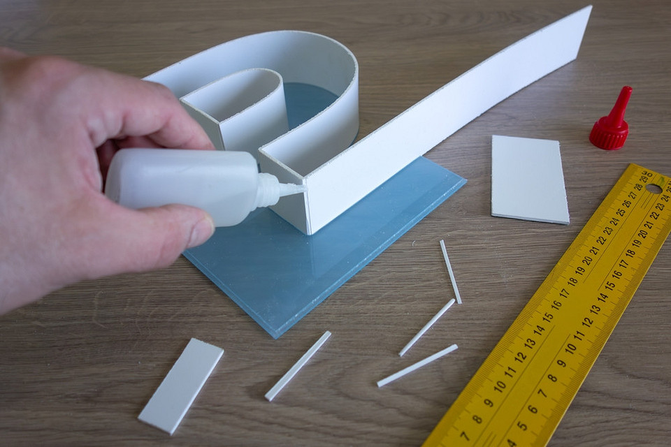 Narzędzia do naprawy plastiku: pistolet do kleju, szpachelka i papier ścierny