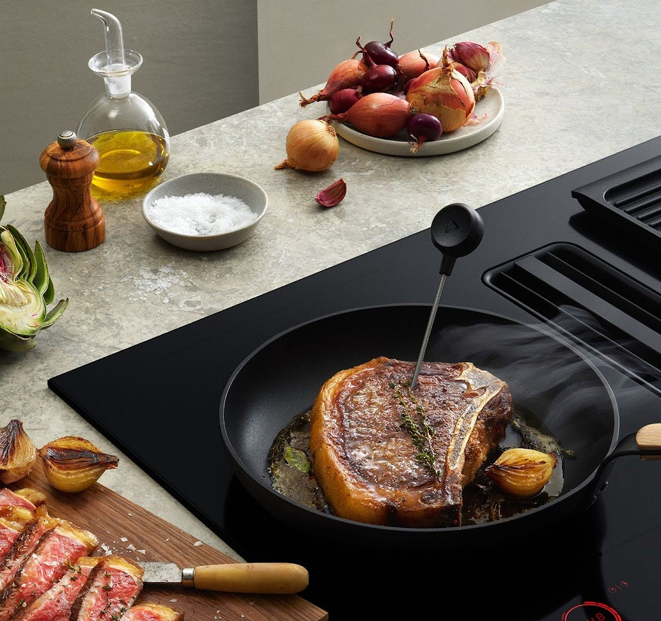 Przyszłościowa kuchnia: płyta indukcyjna zintegrowana z okapem zapewnia ciche i komfortowe gotowanie.