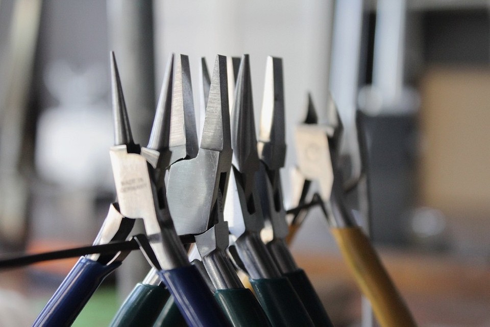 Pasatize i płaskoszczypce na stole warsztatowym: gotowość do różnych zadań.