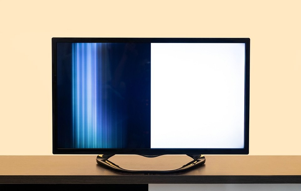 Telewizor z pasami Różnokolorowe pionowe pasy na ekranie telewizora, sugerujące problemy z elektroniką.