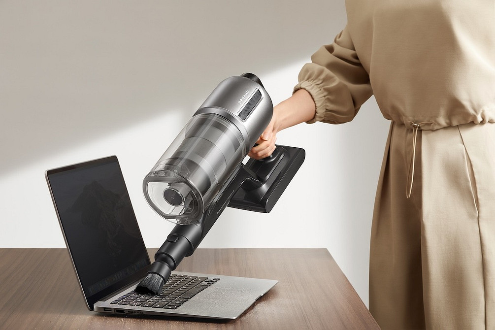 Automatyzacja sprzątania domu Szary robot sprzątający poruszający się po panelach, inteligentny dom.