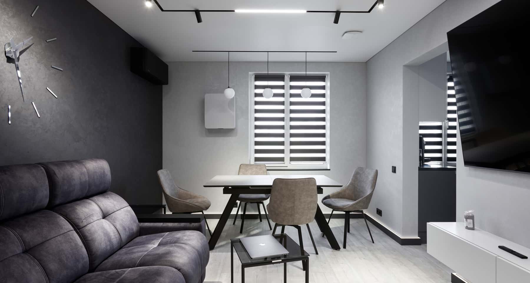 Szara kuchnia w stylu loft Nowoczesna kuchnia w odcieniach szarości z minimalistycznymi frontami i drewnianymi akcentami.