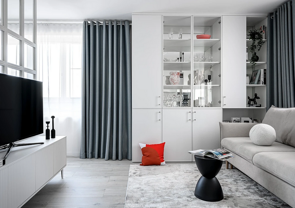 Szary laminat w salonie z roślinami i naturalnym światłem, ciepła aranżacja.