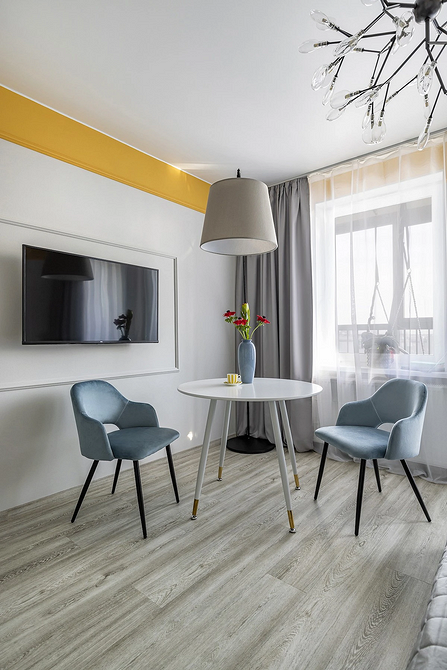 Elegancka jadalnia z szarą podłogą, drewnianym stołem i krzesłami w stylu vintage.