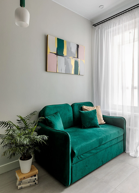 Sypialnia z szarą podłogą, jasnymi tekstyliami i subtelnymi dekoracjami.