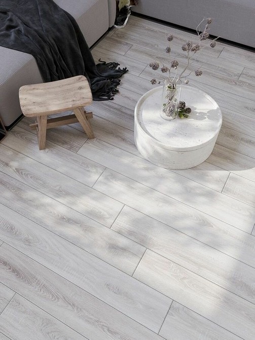 Szary laminat na podłodze w salonie, imitujący naturalne drewno, tworzący ciepły wygląd.