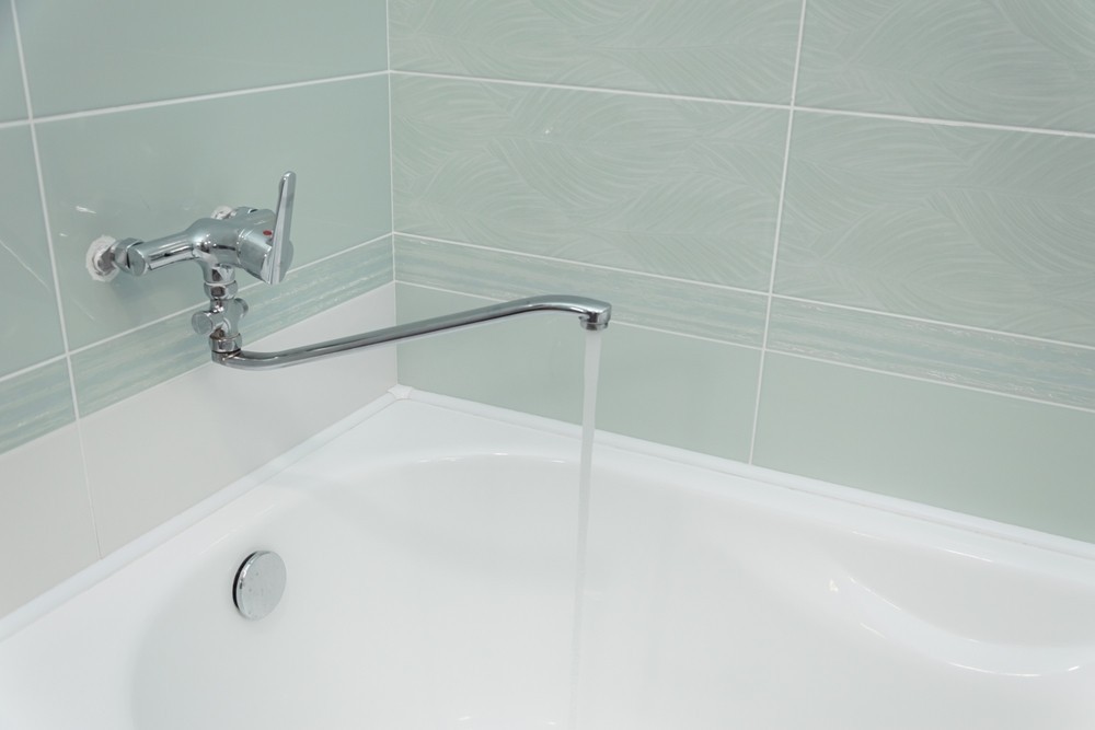 Demontaż cieknącej baterii kuchennej w celu naprawy lub wymiany uszczelek.