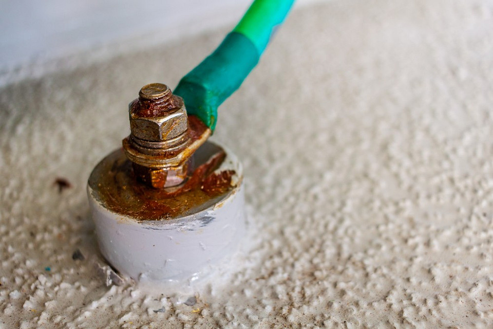 Elementy instalacji uziemiającej: uziemienie szpilkowe i przewody ochronne w budynku.