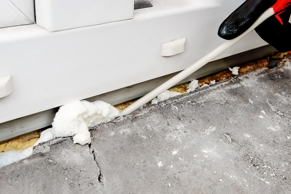 Wypełnianie szczelin pianką montażową podczas instalacji parapetu PCV. Uszczelnianie.